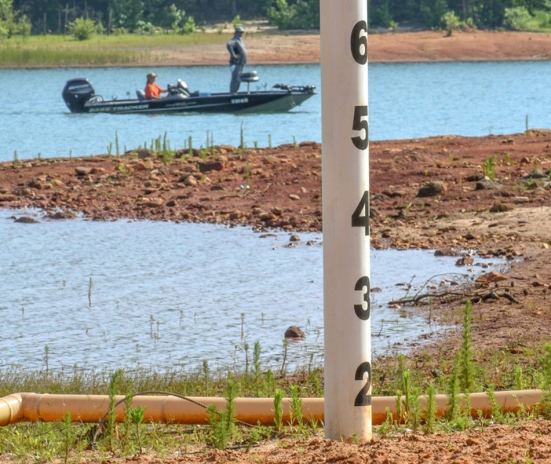 A boater rides by a marker along the shoreline at Singing Pines Recreation Area at Lake Hartwell, getting a look at Georgia drought conditions.