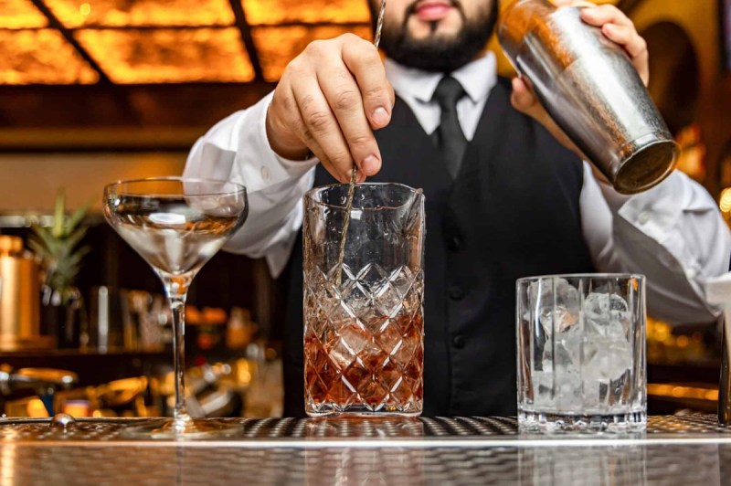 Bartender mixing cocktails behind the bar in one of many speakeasies in Atlanta